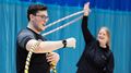 A student grapples with a hula hoop around his arm while friend looks on laughing and whirling a hoop around her hand during a MOVE class at the Centre for Sport. 