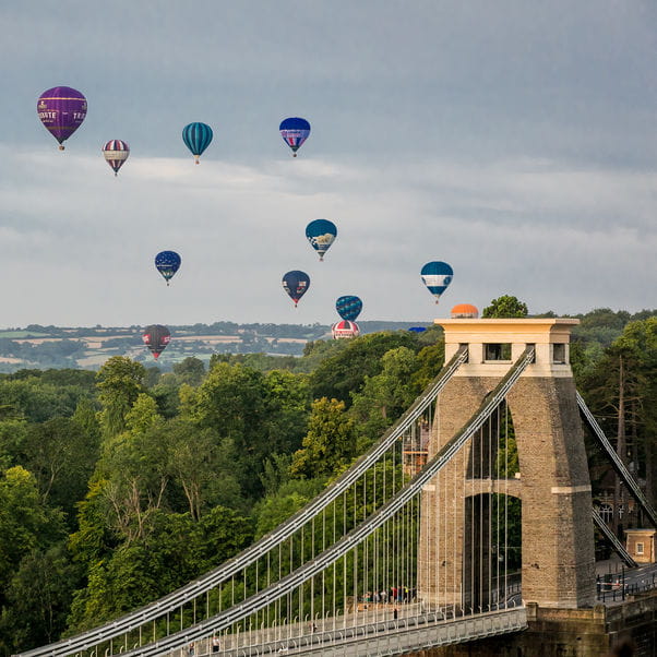 Hot air balloons flying over Clifton Suspension Bridge.