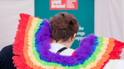 Closeup of someone wearing rainbow wings at Bristol Pride.