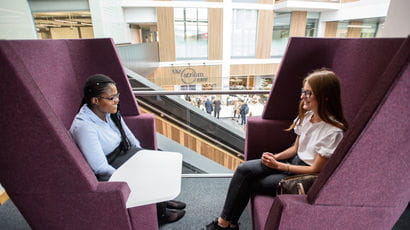 Business students talking in giant chairs