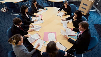 People having a meeting around a table.