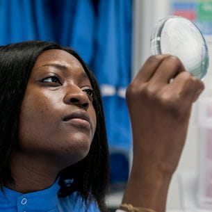 Midwifery student holding up a microscope