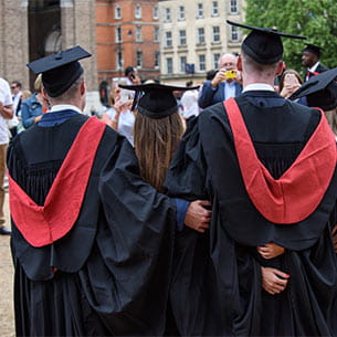 Back shot of a group of students posing for photographs at a UWE Bristol graduation ceremony