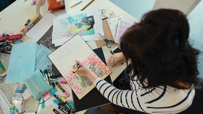 An illustration student working with pen and paper
