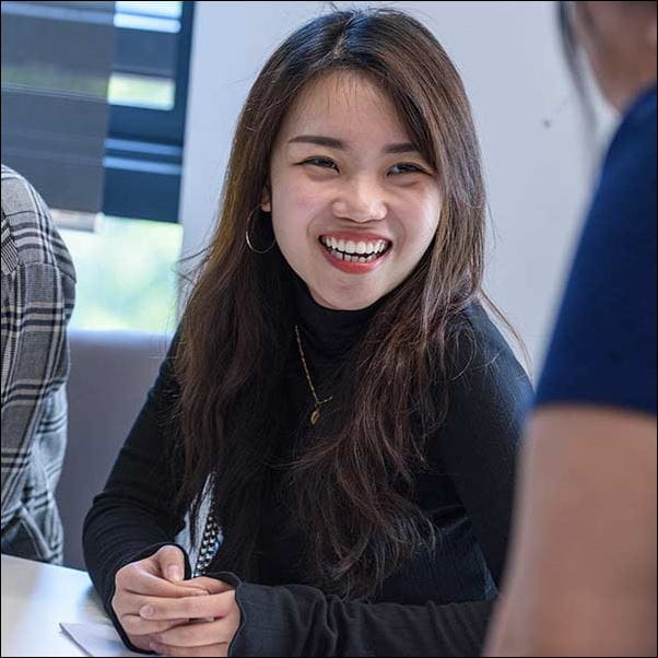 A student smiling, in a classroom.