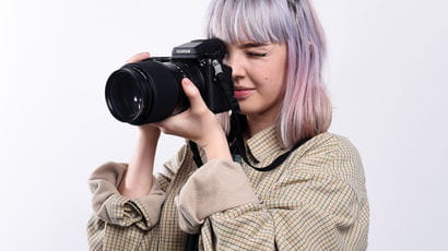 A student looking through the lens of a large camera