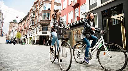 Two females cycling through Copenhagen city centre