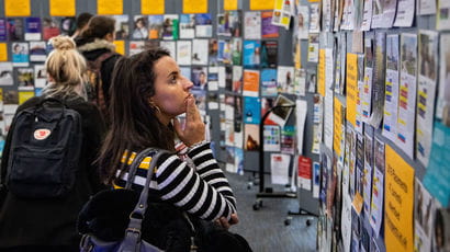 A female student browses a stand at the employer fair
