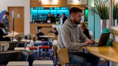 Person sitting in a café on their laptop.