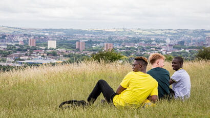 Students sitting in Stoke Park overlooking Bristol City Centre.