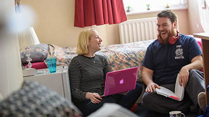 Two people sitting on a bedroom floor