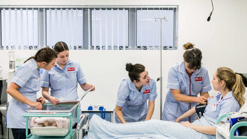 Midwifery students with a dummy in the Skills Simulation Suite on Glenside Campus.
