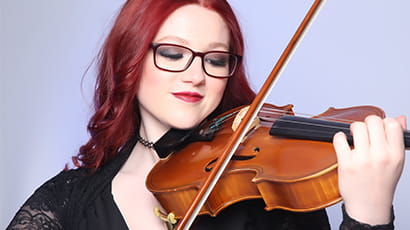 Woman with red hair and glasses playing viola