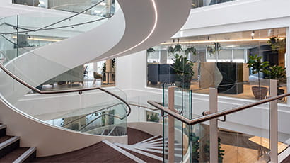 The interior of Osbourne Clarke's offices, an open spiral staircase leading to open plan offices