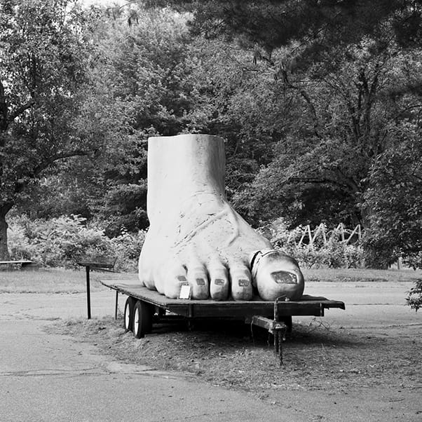 Image of a large foot on a raised platform taken from the SLANT series by Aaron Schuman