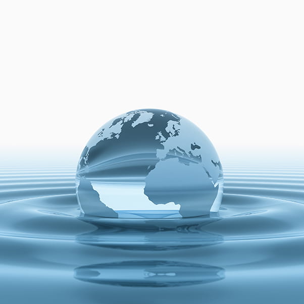 Image of Earth in the form of a water droplet situated on water surface creating a ripple effect.