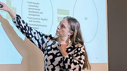 Image of Noelle Quinevet pointing to the presentation screen at the RIPIL Inaugural Showcase Event on 6 December 2023.