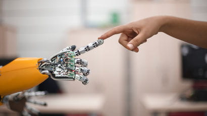 Robotic arm touching a human's hand.
