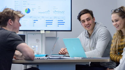 Three students using a screen to work together.