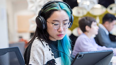 Student wearing headphones looking at laptop