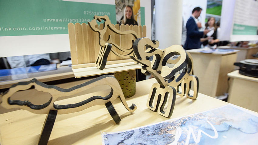 Small wooden animals on the table during a degree show