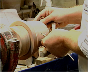 Neil Burton turning the clay vase on a lathe