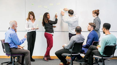 Group of UWE Bristol staff working on a whiteboard.