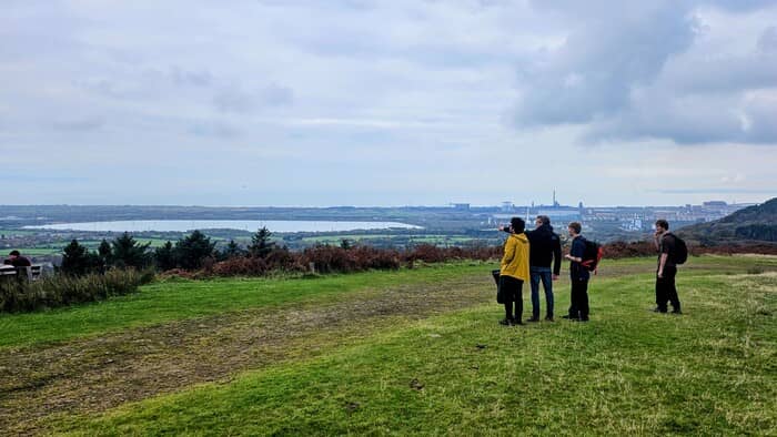 Margam Park, Port Talbot, Wales – Staff and students look over the natural landscape and the Port Talbot steelworks as part of a cartographic transect activity during fieldwork in the parkland.