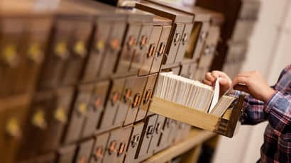 A row of filing cabinets with one drawer open and files showing
