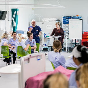 Lecturer addressing a group of nursing students.