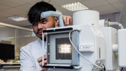Student using radiography equipment