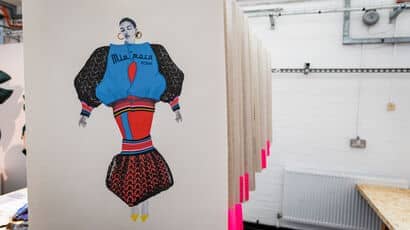 Inside an art studio with artwork hanging along the side of the room