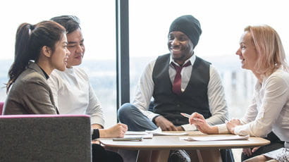 Group of smartly dressed people talking at a table.