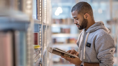 Student reading a book in a library