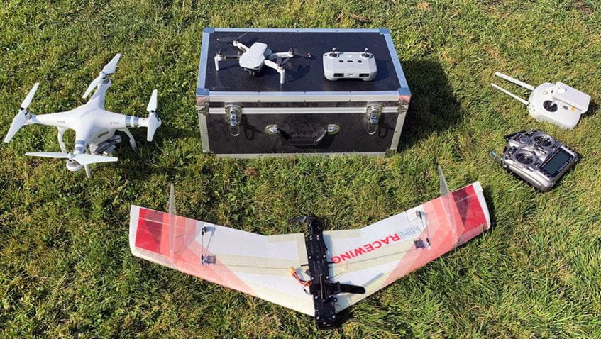 A drone and various flight equipment in a field.