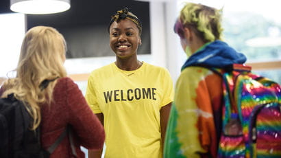 Student welcoming two prospective students at an Open Day.