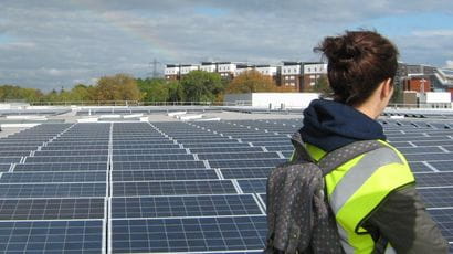 Student doing a masters in sustainability looks at the solar panels on campus