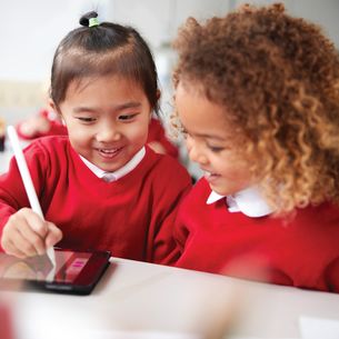 Two children playing with a tablet