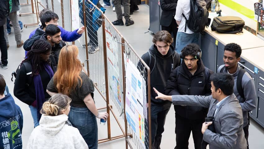 Students gathered around displays during the Engineering Project Week event.