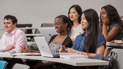 A group of students sat facing the front of a lecture hall