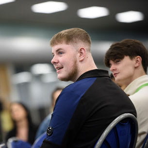 Students sat smiling and facing each other. Students sat smiling and facing each other.
