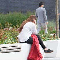 Someone sitting at a seat on campus.