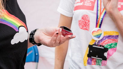 Closeup of UWE Bristol staff members wearing t-shirts with rainbows on at Bristol Pride.