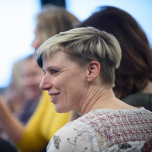 Member of staff smiling at a meeting. 