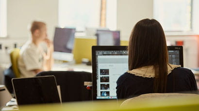 Students using computers in a study room.