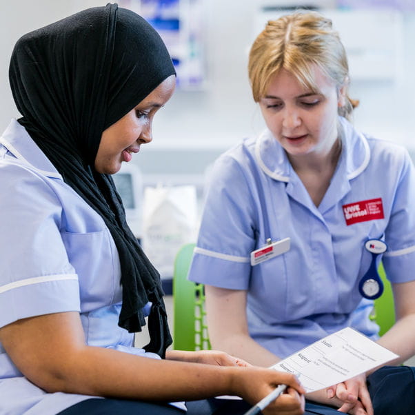 Two student nurses working on a ward.