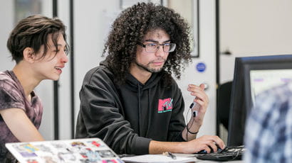 Students working on a computer in a study space.