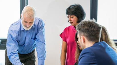 Staff members having a discussion around a table.