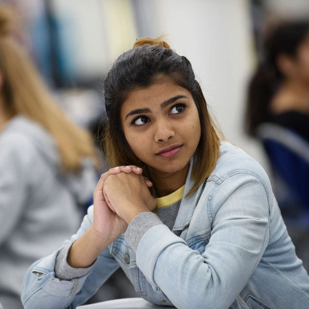 Girl with hands together looking thoughtfully