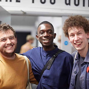 Three undergraduate students smiling at the camera.